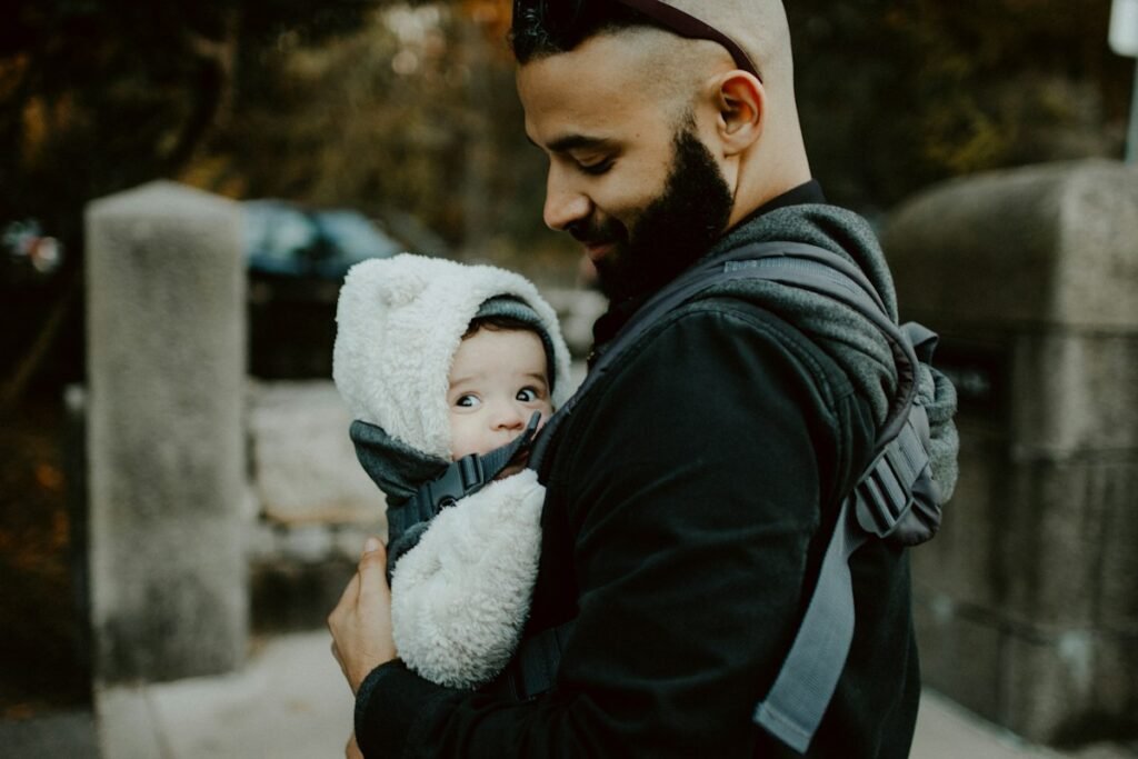 Parent carrying a bundled-up baby in a carrier